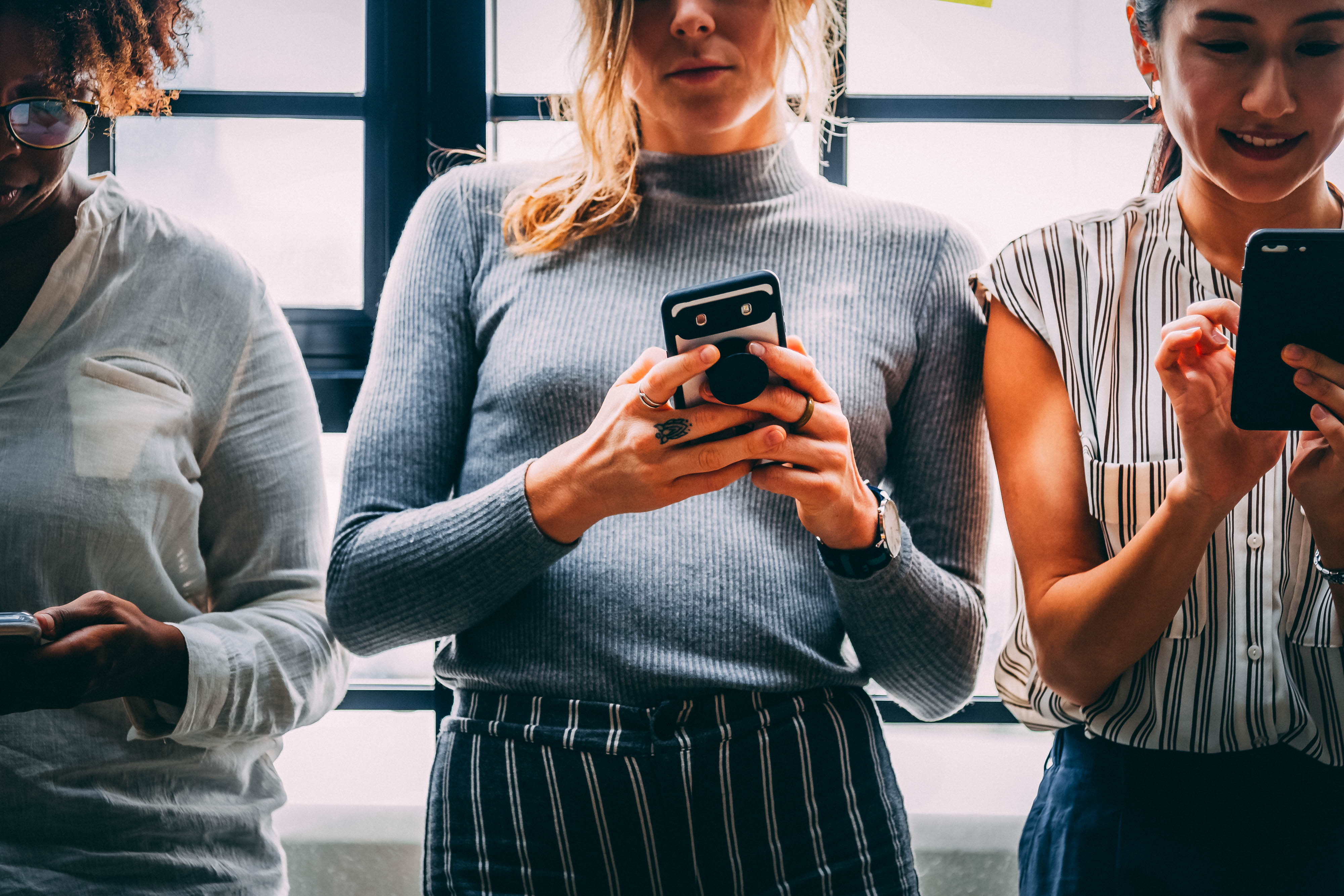 Group of women looking at their phone screen.