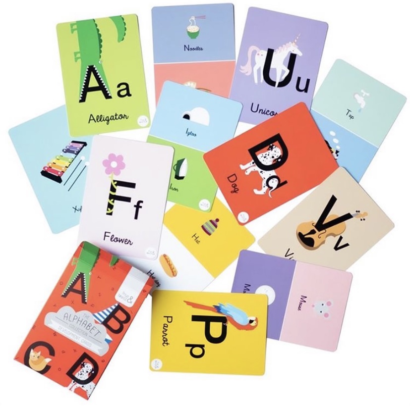 Alphabet flashcards scattered.